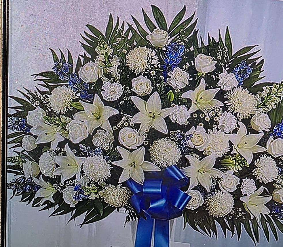 White sympathy basket with blue ribbon
