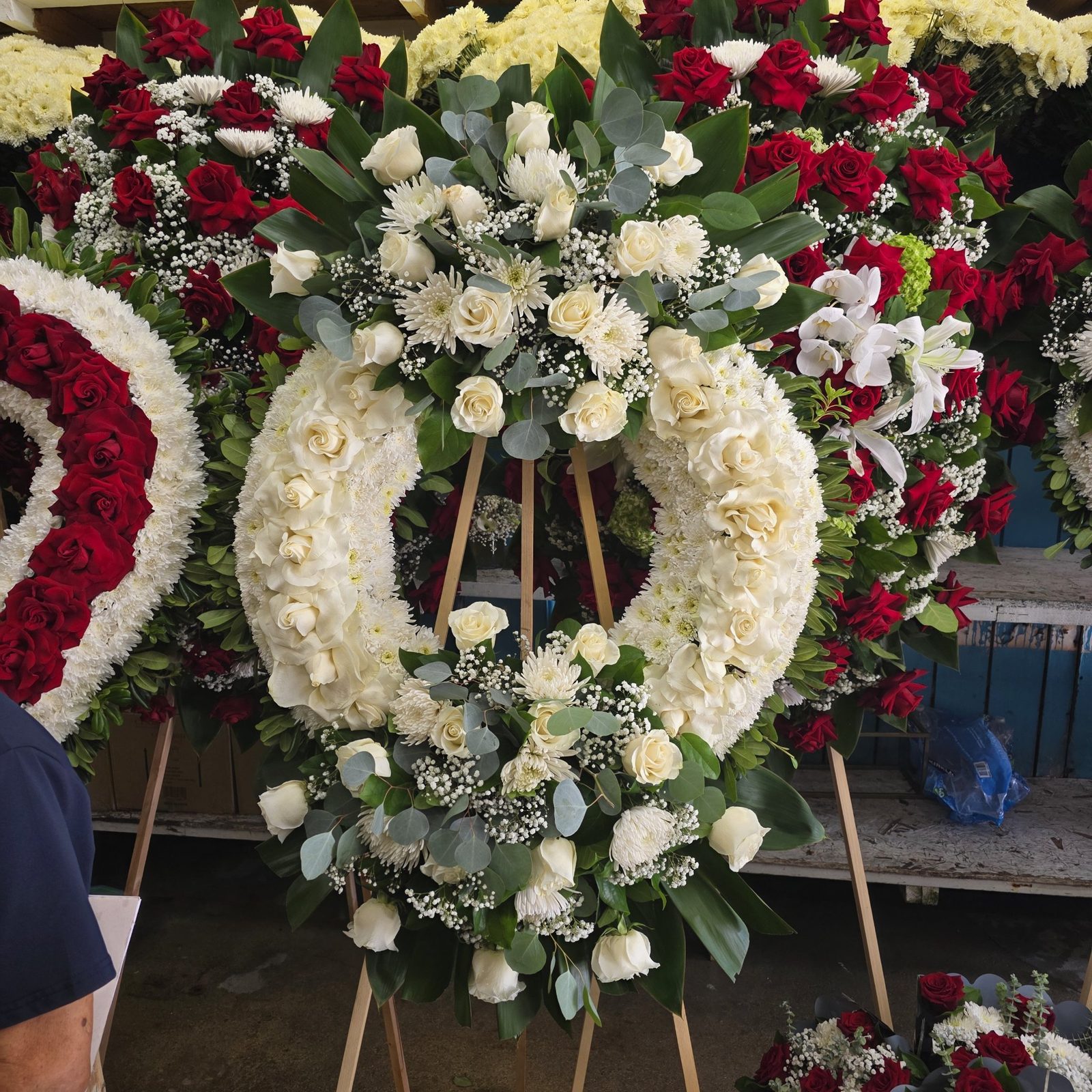 Large white sympathy wreath with red and white wreaths, made to order in the LA Flower District